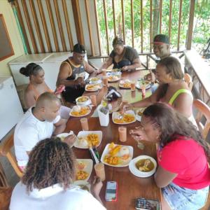 巴亚索拉诺Cabañas las perlas的一群坐在桌子旁吃食物的人