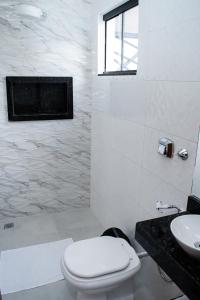 锡诺普Aquarela Apart Hotel的白色的浴室设有卫生间和水槽。