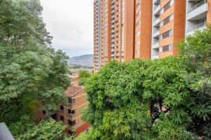 麦德林Apartamento a 3 min del Hospital Pablo tobón uribe的一座高楼前的树