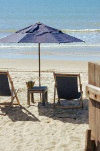 布希奥斯Pousada Villa Rasa的海滩上的两把椅子和一把遮阳伞