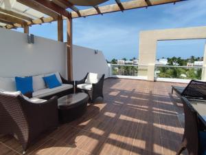 蓬塔卡纳Cortesito santana的阳台设有带椅子和沙发的庭院。