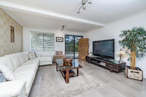 Upper SwanSwan Valley的客厅配有白色沙发和电视