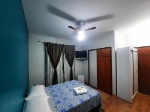 卡尚布Alvorada Guest House的一间卧室配有吊扇和一张床