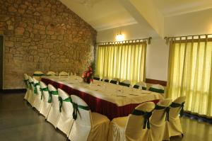 钦纳卡纳蒙纳山间俱乐部度假酒店的一间会议室,配有长桌子和白色椅子