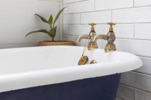巴拉腊特Mena-close to Ballarat CBD, self check-in with bath and cot的浴室水槽设有两个水龙头和植物