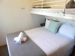 莫阿马莫亚马河滨假日公园的一间小卧室,配有一张带毛巾的床