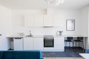 布鲁塞尔Smart Appart - Clmenceau的厨房配有白色橱柜和蓝色沙发