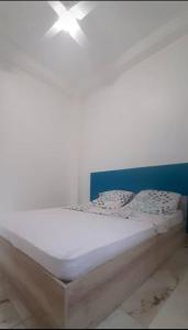 法兰西堡Appartement T3 Cœur De Ville Patio的一张带蓝色床头板和枕头的白色床