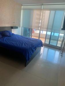 通苏帕Departamento amoblado en Tonsupa Diamond Beach的一间卧室设有蓝色的床和玻璃墙