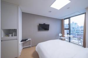 春川Chuncheon Bella Residence的酒店客房设有白色的床和窗户。