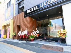 东京HOTEL LiVEMAX Asakusabashi-Eki Kitaguchi的窗户上有鲜花的酒店前方的商店