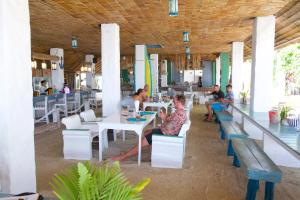 通萨拉Lime N Soda Beachfront Resort的一群坐在餐厅桌子上的人