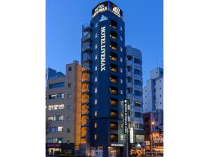 东京HOTEL LiVEMAX Asakusabashi-Ekimae的一座高大的蓝色建筑,上面有标志