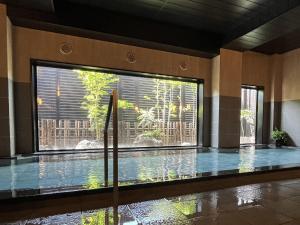 熊谷熊谷路途酒店 的一座带大窗户的建筑中的游泳池