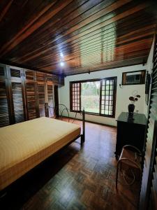 约恩维利Hotel Jussara Cultural - Joinville的一间带一张床的卧室,位于带木制天花板的房间内
