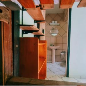 约恩维利Hotel Jussara Cultural - Joinville的浴室设有棕色的门和水槽。