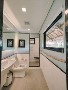 卢纳将军城Kaimana Resort Siargao的一间带卫生间、水槽和窗户的浴室