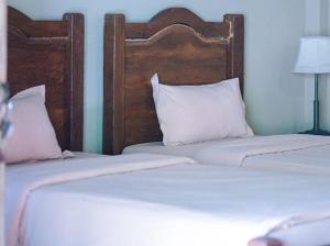 婆罗浮屠河畔鲁玛达尔玛2旅馆的卧室设有两张单人床和白色枕头。