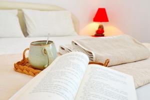 蒂瓦特Stradioti Apartments的床上的开放式书,带咖啡