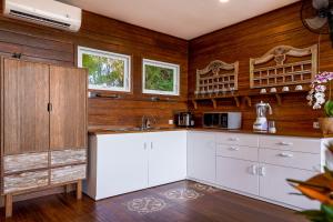 克罗柏坎Villa Atra Bambulogy by Nagisa Bali的厨房配有白色橱柜和木墙