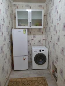 奇姆肯特Deluxe的厨房配有冰箱和洗衣机。