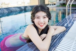 岘港Sea Wind Hotel by THG的躺在游泳池里的年轻女人