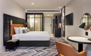 墨尔本Dorsett Melbourne的配有一张床和一张书桌的酒店客房