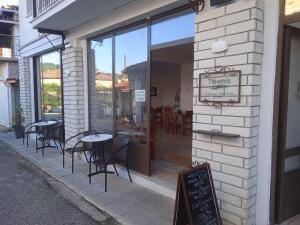 DolianáThiamis Guesthouse的餐厅设有窗户外的桌椅