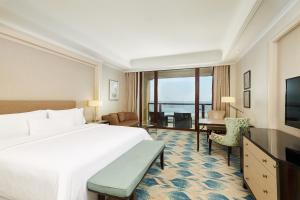 舟山舟山朱家尖绿城威斯汀度假酒店的酒店客房设有一张大床和一张书桌。