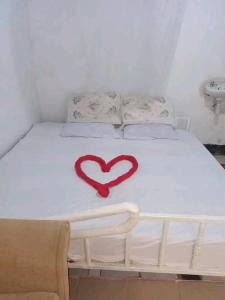 奈瓦沙SOFA CAMP NAIVASHA的一张白色的床,上面有红色的心