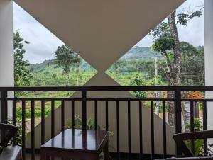 MundakāyamRoyalton Residency的阳台享有房屋美景,配有桌子