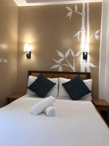 班塔延岛Anahaw Seaside Inn的卧室配有白色的床和2个枕头