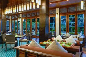 迈考海滩迈考海滩万豪酒店- 普吉岛的餐厅设有桌椅和窗户。