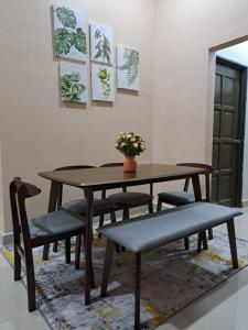 JeliHomestay Jeli - Cattleya Inn Muslim的餐桌、椅子和桌子,上面有植物