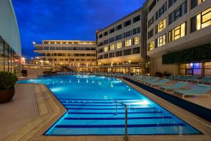 伊兹密尔伊兹密尔卡亚温泉&会议中心酒店的大楼前的大型游泳池