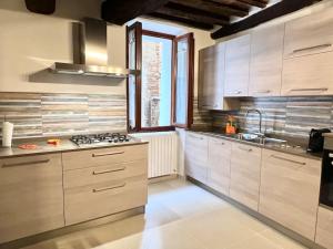 锡耶纳Franciosa Lodge - Cattedrale的厨房配有白色橱柜和炉灶烤箱。