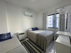 巴拉奈里奥-坎布里乌Aconchegante apartamento no centro em Balneário Camboriú SC的一间小卧室,配有两张床和窗户