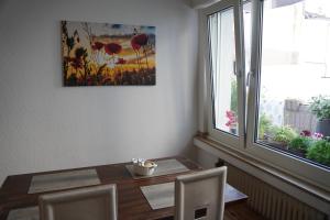 亚琛Bright, spacious apartment with a lovely terrace in the heart of Aachen的一间带桌子和窗户的用餐室