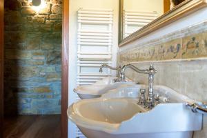 弗留利地区奇维达莱Lis Fadis Wine Relais的一间带三个水槽和石墙的浴室