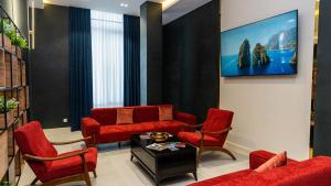 塔什干Garnet Mir Hotel的客厅配有红色椅子和电视