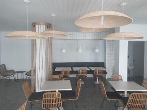 下皮尔戈斯E.J. Pyrgos Bay Hotel的用餐室配有桌椅和吊灯