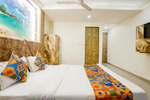 艾哈迈达巴德FabExpress Apollo I的一间卧室配有一张带色彩缤纷枕头的大床