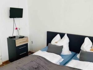 哈根Nordsee Appartement in Hagen的一间卧室配有蓝色的床和白色枕头
