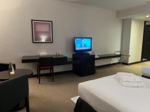 阿布扎比阿詹辛拉俱乐部酒店的酒店客房,配有床和电视