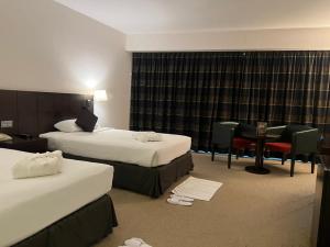 阿布扎比阿詹辛拉俱乐部酒店的酒店客房配有两张床和一张书桌