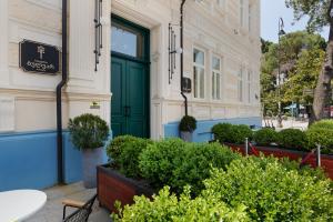 巴统Boulevard Hotel Batumi的一座种植了盆栽植物的建筑上的绿门