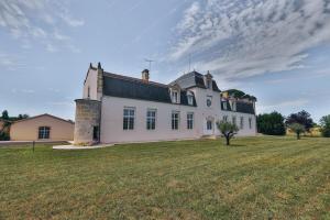 Domaine Grand Piquecaillou - Appartement Bordeaux的一座大型白色房子,设有大片草地