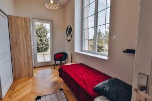 Domaine Grand Piquecaillou - Appartement Bordeaux的一间卧室设有红色的床和2个窗户。