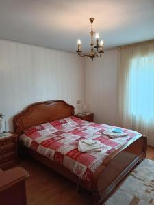 帕苏德尔托纳莱Appartemento Casa Giuli的一间卧室配有一张带红白色棉被的床