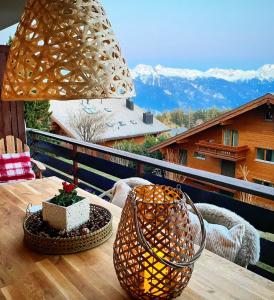 克莱恩 蒙塔纳Window on Crans Montana, Appartement avec vue sur les Alpes的山景阳台上配有带台灯的桌子